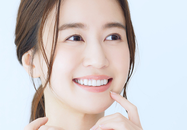 歯をみせてほほ笑む女性